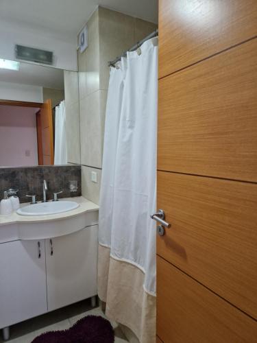 een badkamer met een wit douchegordijn en een wastafel bij Altos del Pampa in Santa Rosa