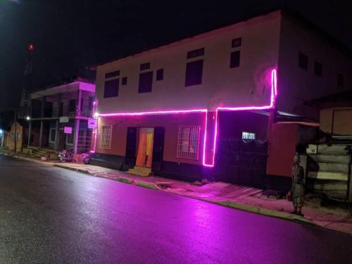 ein Haus mit rosa Lichtern an der Seite in der Unterkunft BM Akwaba in Palimé