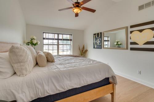 a bedroom with a bed with a ceiling fan and a mirror at Prime Peoria Retreat with Deck and Fireplace! in Peoria