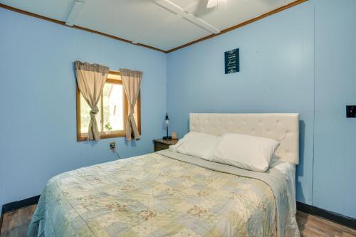 Dormitorio azul con cama y ventana en French Lick Getaway with Deck, Grill and Fire Pit!, en French Lick