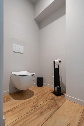 a bathroom with a toilet sitting on a wooden floor at B&B T'Rest - Park ter Rijst in Heikruis