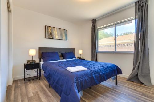 um quarto com uma cama azul e uma janela em Quiet Ridgecrest Vacation Rental with Private Yard! em Ridgecrest