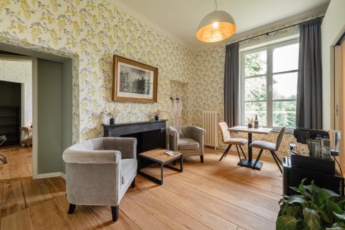 a living room with a fireplace and a table at B&B T'Rest - Park ter Rijst in Heikruis