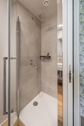 a shower with a glass door in a bathroom at B&B T'Rest - Park ter Rijst in Heikruis