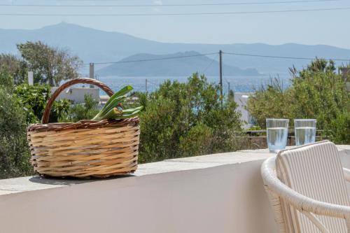 a basket and two glasses sitting on a ledge with a table at Studios Farma in Agia Anna Naxos
