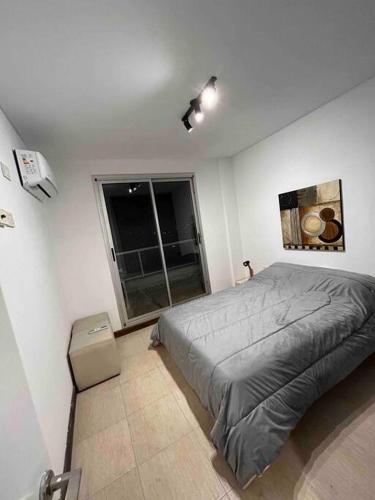 Un dormitorio con una cama grande y una ventana en Departamento a estrenar en Buenos Aires