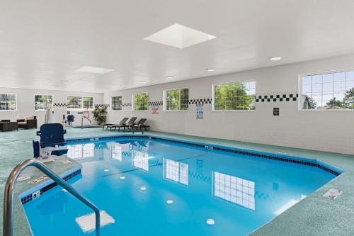 a large swimming pool with blue water in a building at The Ashley Inn & Suites in Lincoln City