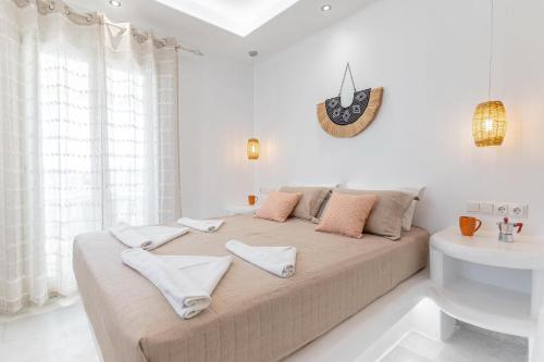 a white bedroom with a large bed and a sink at Studios Farma in Agia Anna Naxos