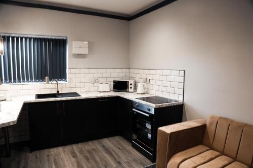 een kleine keuken met een wastafel en een magnetron bij Lumiere apartments 