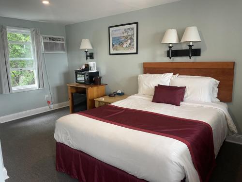 a bedroom with a large bed with a red blanket at The Cutty Sark in Dennis Port