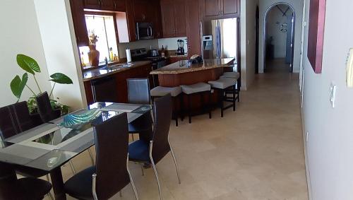 a kitchen with a bunch of chairs and a bar at Playa Bonita Rosarito in Rosarito