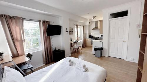 sypialnia z białym łóżkiem i kuchnią w obiekcie Kings Road Retreat - Affordable Serviced Apartments in Chelsea w Londynie