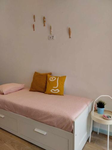 a bedroom with a bed with a yellow pillow on it at Maria Sardinha_As Três Marias in Matosinhos