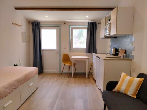 a small room with a bed and a kitchen at Maria Sardinha_As Três Marias in Matosinhos