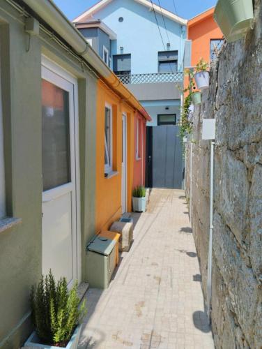 an alley with a white door next to a building at Maria Sardinha_As Três Marias in Matosinhos