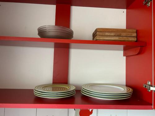 un estante rojo con platos y tazones. en Departamento centro Mendoza en Mendoza