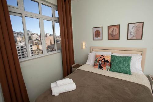 um quarto com uma cama e uma janela grande em Prédio central com apartamentos reformados em São Paulo