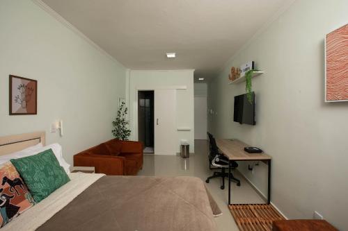 um quarto com uma cama, uma secretária e um sofá em Prédio central com apartamentos reformados em São Paulo