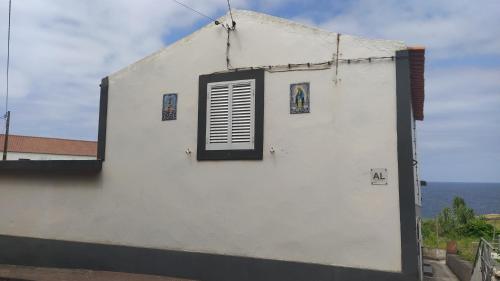 a window on the side of a white building at Casa dos Fenais in Praia da Graciosa