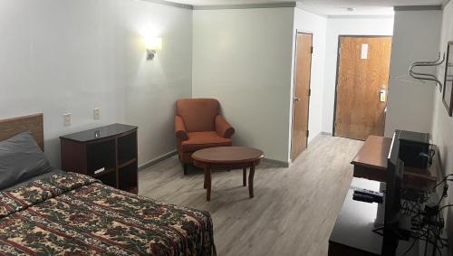 a hotel room with a bed and a chair at Countryside Inn Motel Albert Lea in Albert Lea