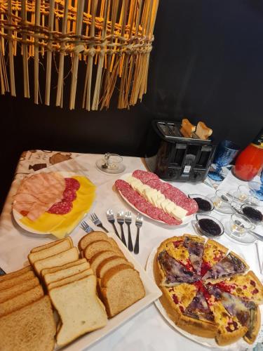 a table topped with different types of bread and meats at HOTEL BOUTIQUE TIERRA DE ISLAS Chiloé in Castro