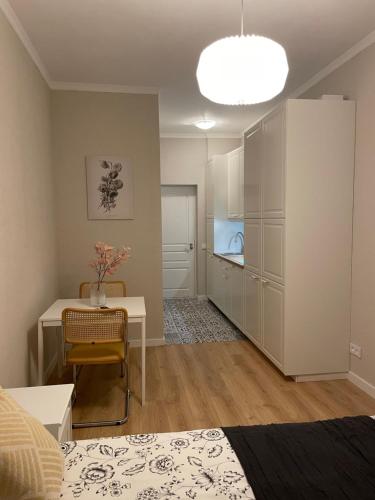 a living room with a bed and a table and a kitchen at Jūros apartamentai in Klaipėda