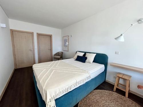 a bedroom with a large bed with blue and white sheets at Sesimbra Califórnia beach front in Sesimbra