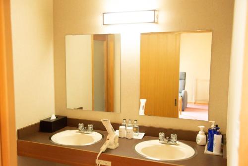 a bathroom with two sinks and a large mirror at Tanakaya in Kurobe