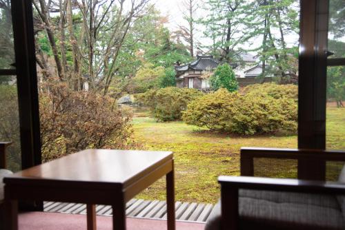 a table and two chairs in front of a window at Tanakaya in Kurobe