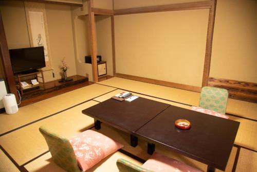 a living room with a table and chairs at Tanakaya in Kurobe