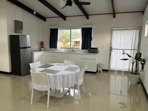 cocina con mesa, sillas y nevera en The Babylon Suite Tortuguero, en Tortuguero