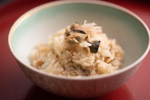 a white bowl filled with rice and mushrooms at Tanakaya in Kurobe