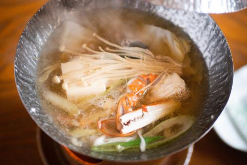 a bowl of soup with noodles and other foods at Tanakaya in Kurobe