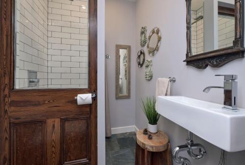 a bathroom with a sink and a wooden door at A rustic cabin in the woods in Orangeville
