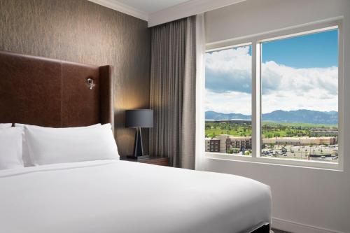 a bedroom with a bed and a large window at Renaissance Boulder Flatiron Hotel in Broomfield