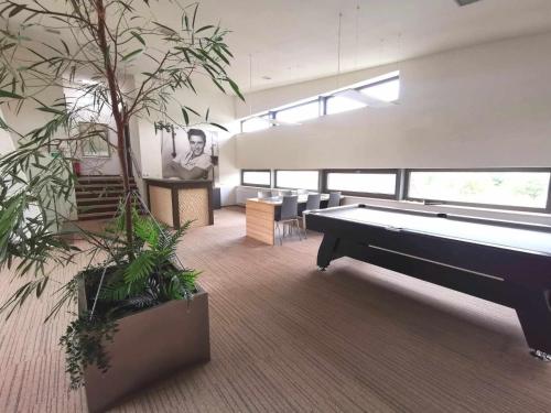 una grande stanza con tavolo da biliardo e piante di Hollywood Dream 