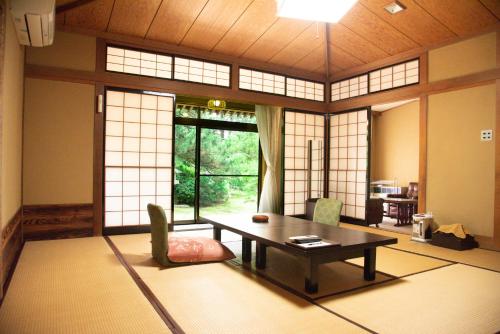 a living room with a table and a window at Tanakaya in Kurobe