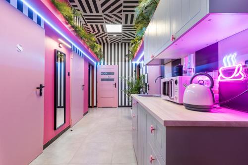 a kitchen with pink walls and a counter with a appliance at VICE CITY Hostel in Wrocław