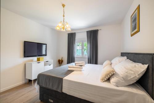 1 dormitorio con 1 cama grande y TV en Apartments with a parking space Solin, Split - 21445, en Solin