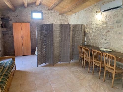 a room with a table and chairs in a room with a wall at Casa Betta in Modica
