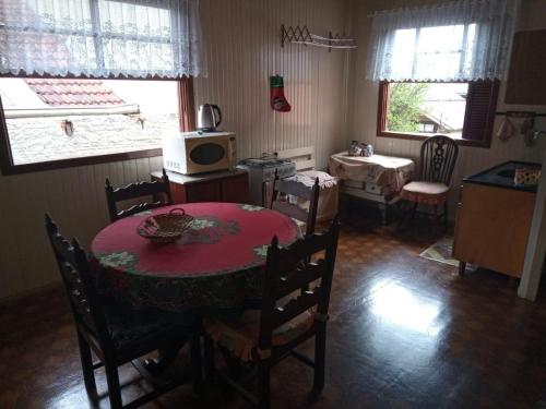 um quarto com uma mesa e cadeiras e um micro-ondas em Casa da vovó em Gramado