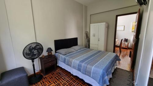 a bedroom with a bed and a fan and a chair at Ap Na Barra, Frente Do Farol in Salvador