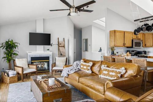 uma sala de estar com um sofá de couro castanho e uma cozinha em Beautiful View Point Villa em Conifer