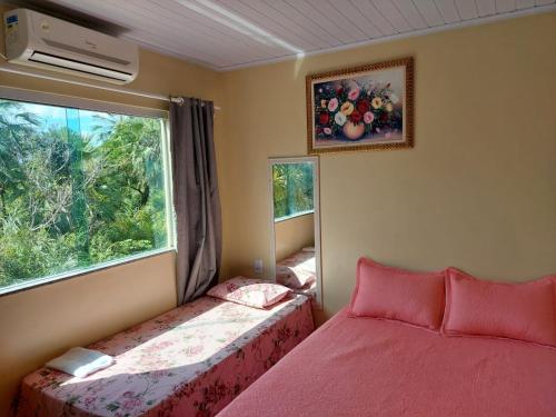 a bedroom with two beds and a window at Lençóis Ville residence - Chalé 38 in Barreirinhas
