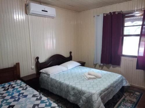 a bedroom with two beds and a window at Casa da vovó in Gramado