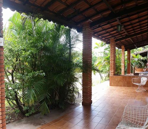 a pavilion with a palm tree on a patio at Chalés Holiday House in Rio Quente