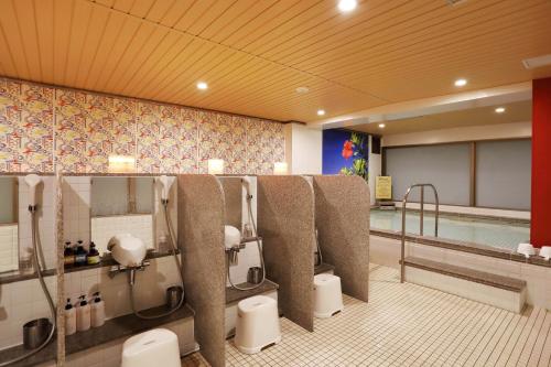 Almont Hotel Naha Omoromachi في ناها: حمام به حمام سباحه مع دورات مياه ومسبح