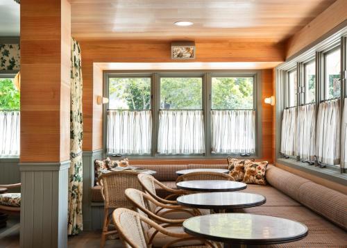 a room with tables and chairs and windows at Le Petit Pali at 8th Ave in Carmel