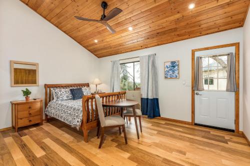 a bedroom with a bed and a wooden ceiling at Sunset Retreat- TWO houses with hot tub, firepit, multiple kitchens, sleeps 20 in Coarsegold