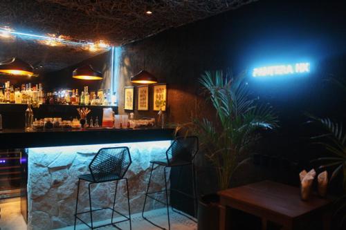 a bar with two chairs and a sign that says chicken hit at Hotel Casa HX - Adults Only in Holbox Island